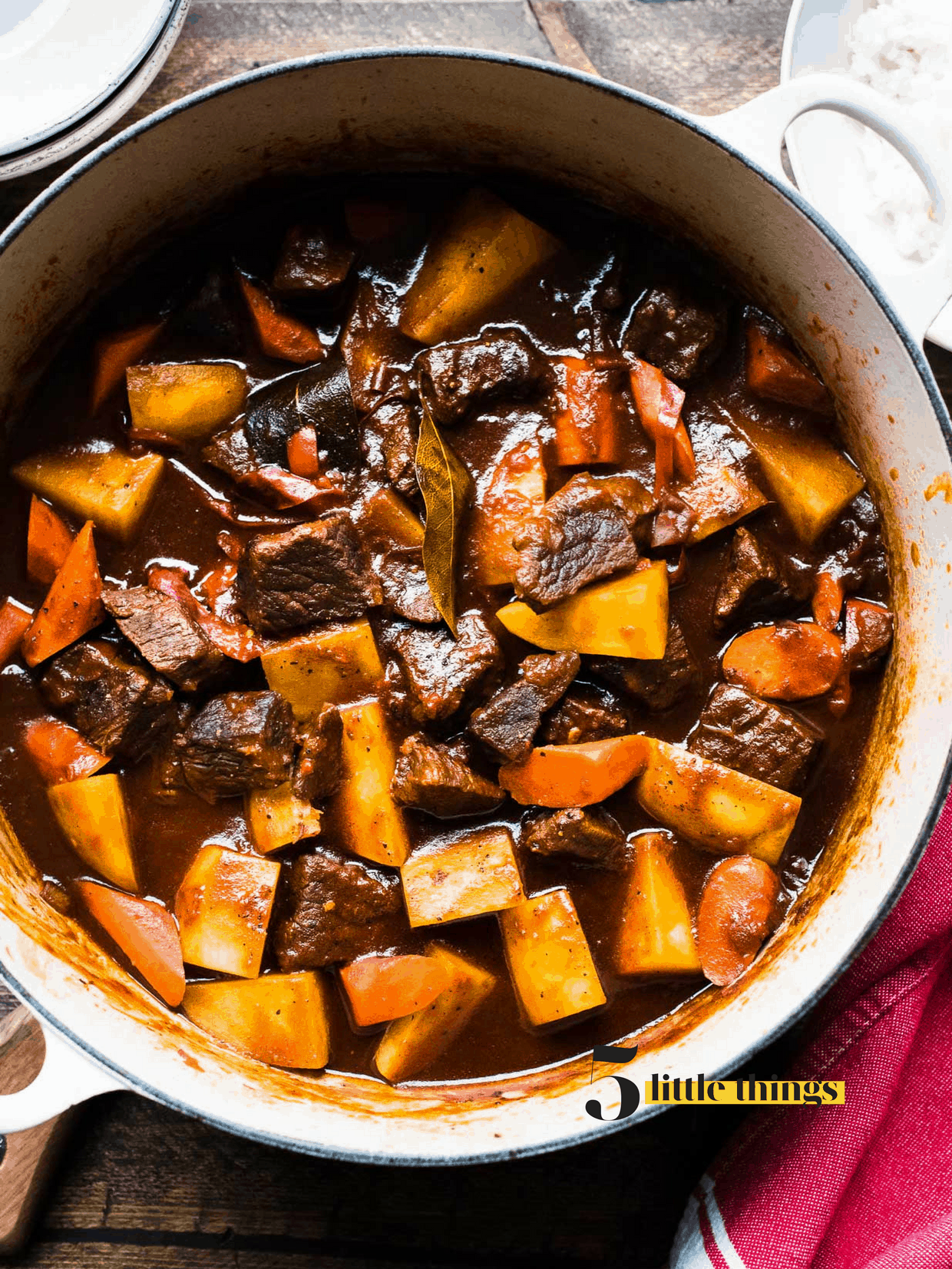 An overhead shot of beef stew in a Le Creuset dutch oven.