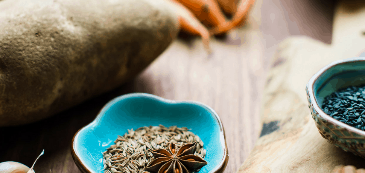 star anise, cumin and spices on a cutting board.