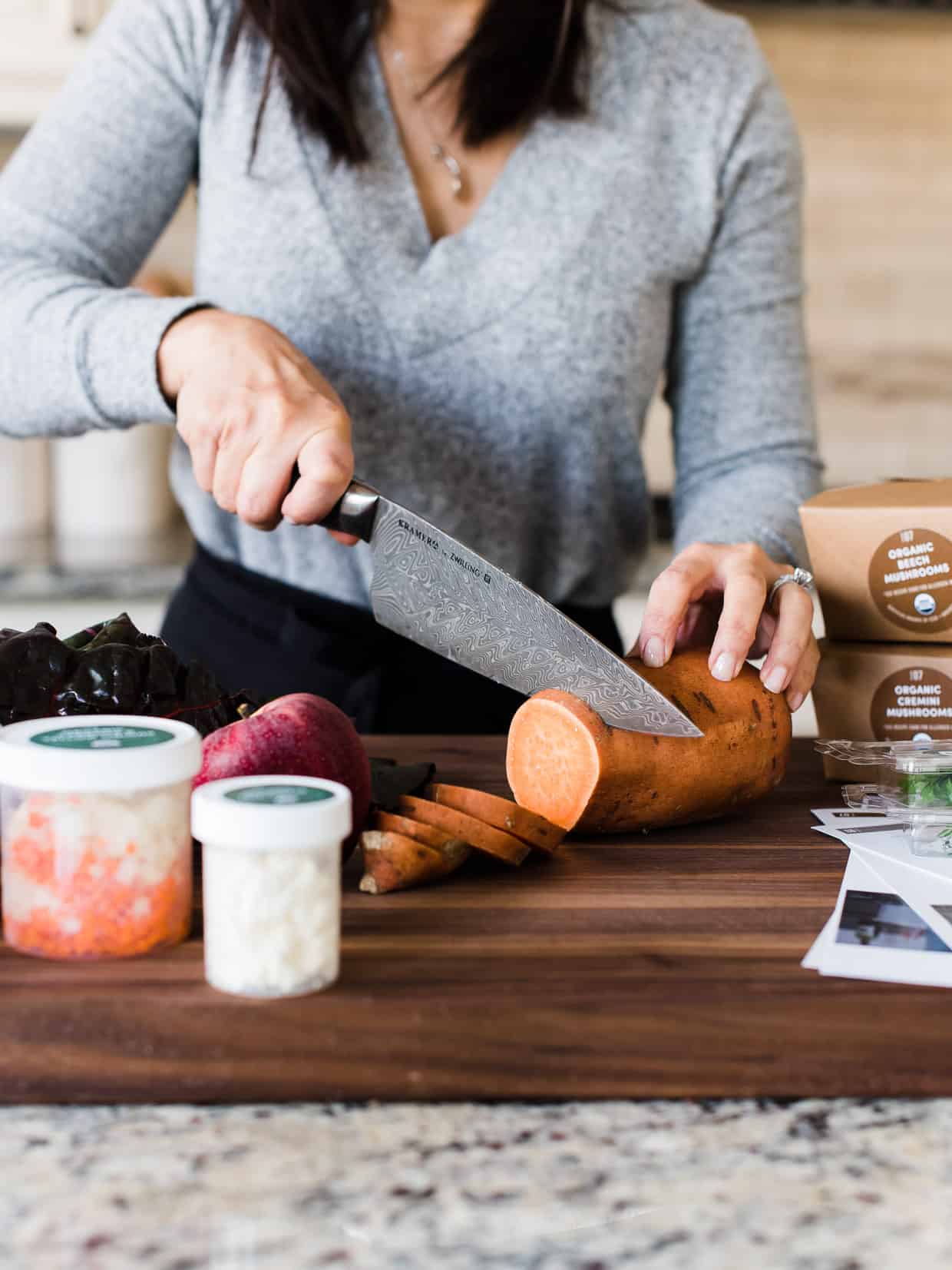 woman slicing sweet potato rounds from Green Chef meal kit