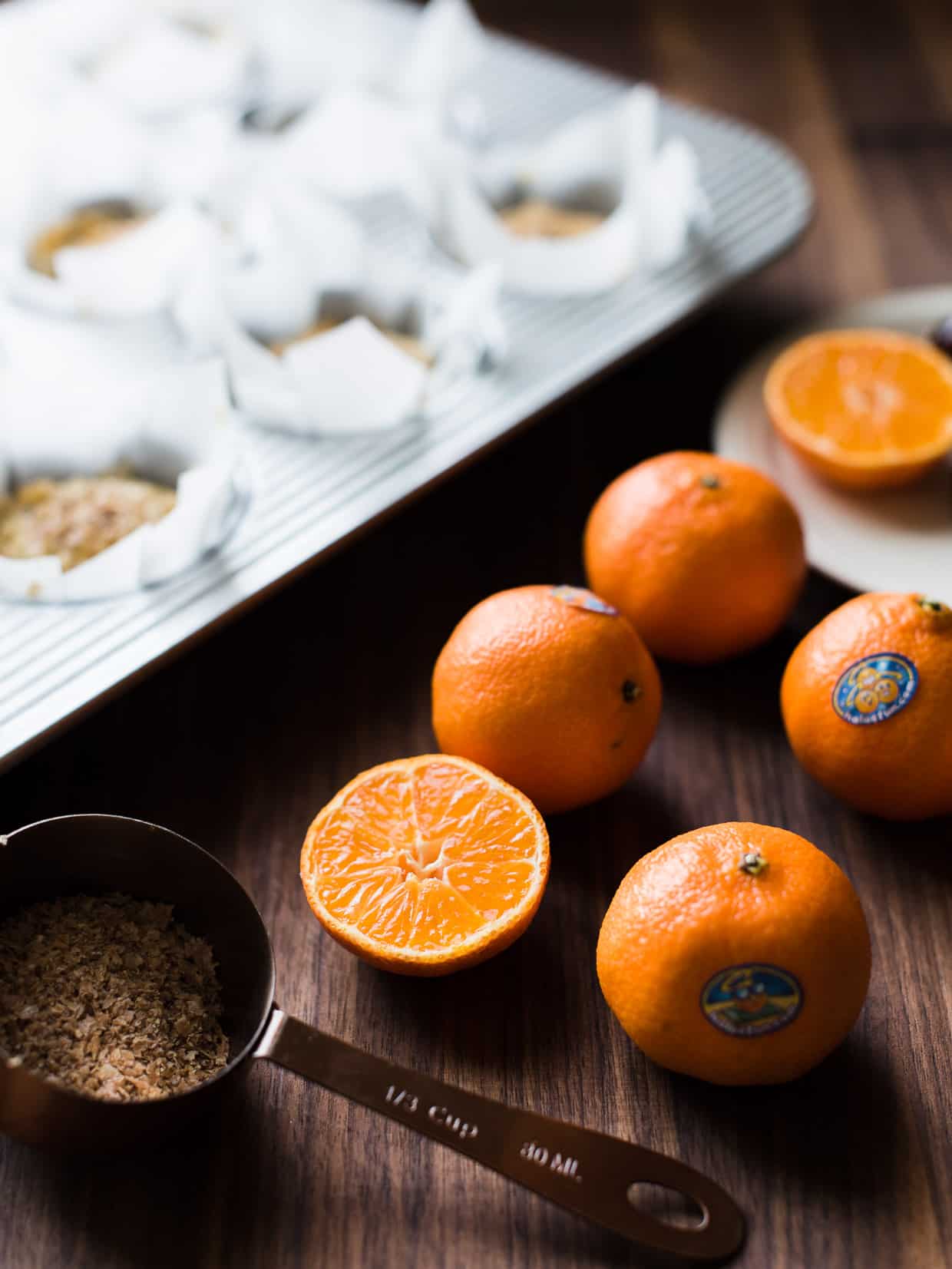 Orange segments of Wonderful Halos with muffins in the background.