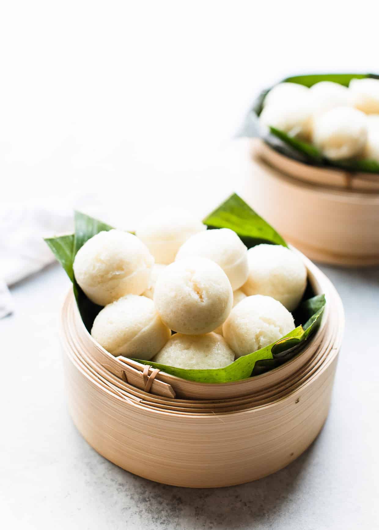 Mini steamed rice cakes, or puto, in a bamboo steamer.