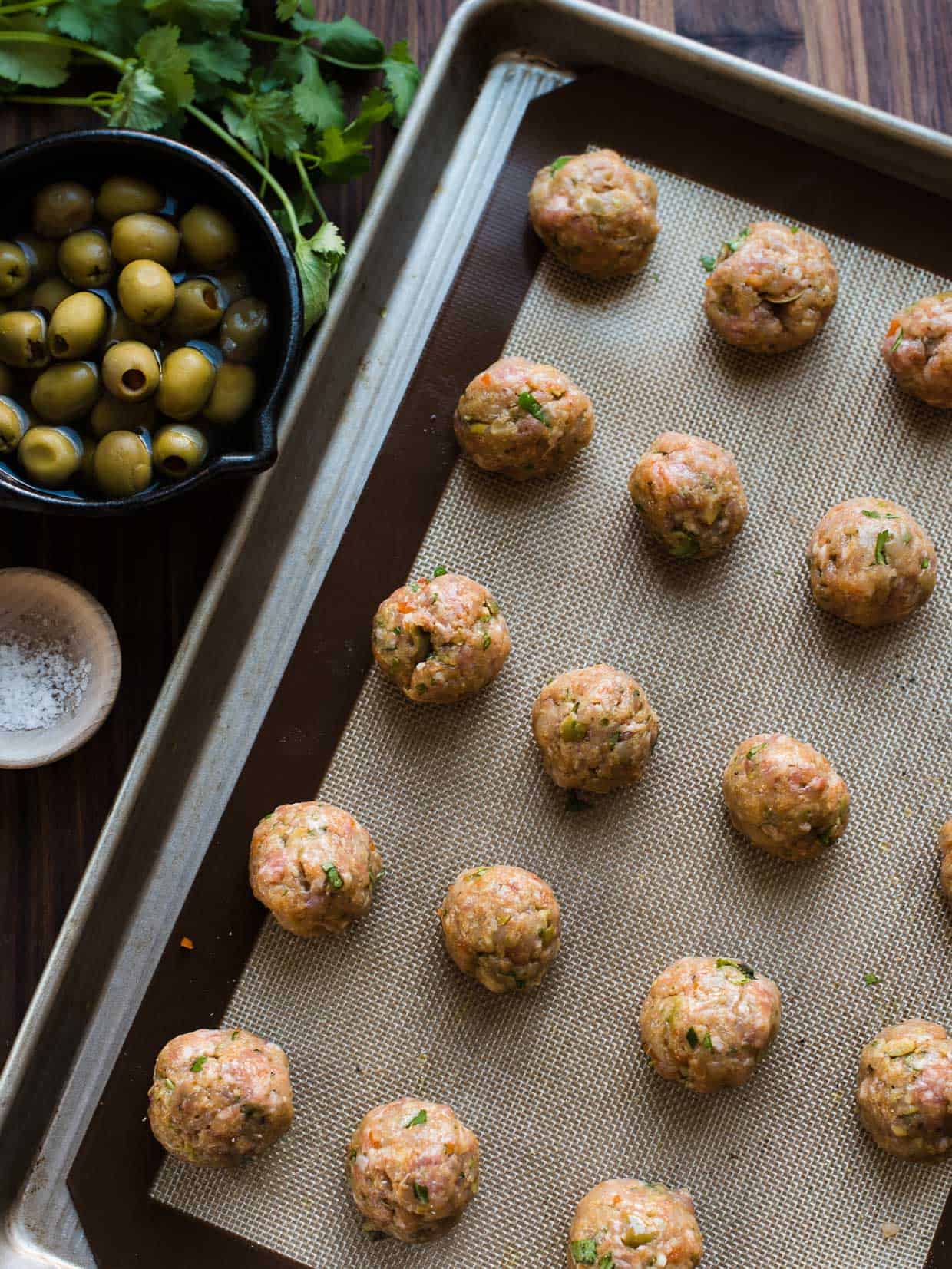 Baking sheet with meatballs for Albondigas with Olives.