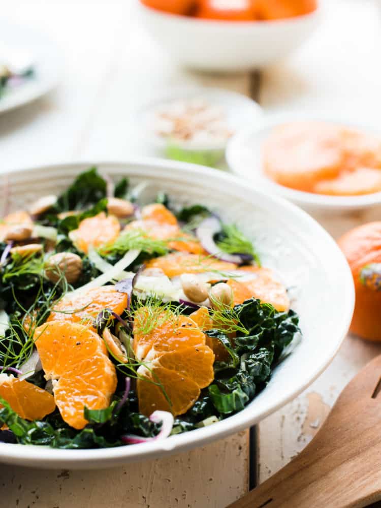 Slices of mandarin oranges on a bed of kale with fennel in Mandarin Orange Kale Salad.