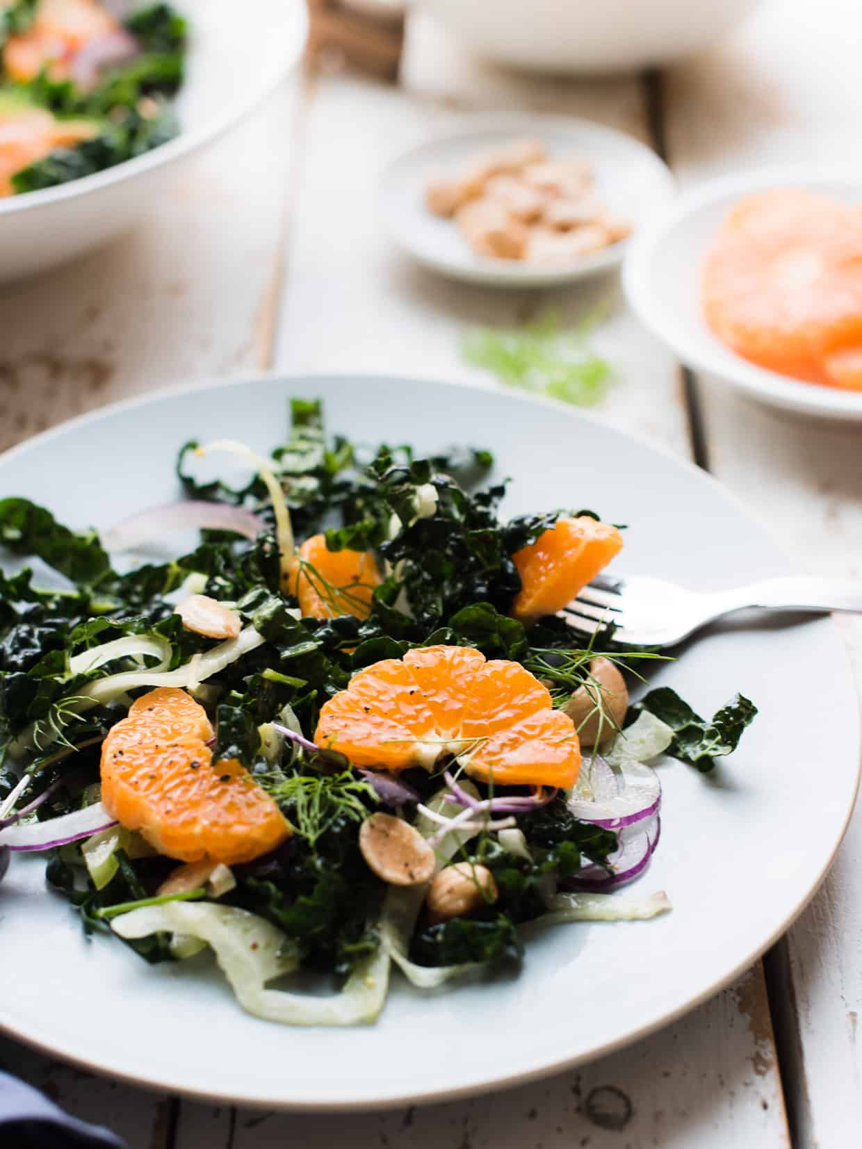 Serving of mandarin orange kale salad on a light blue salad plate