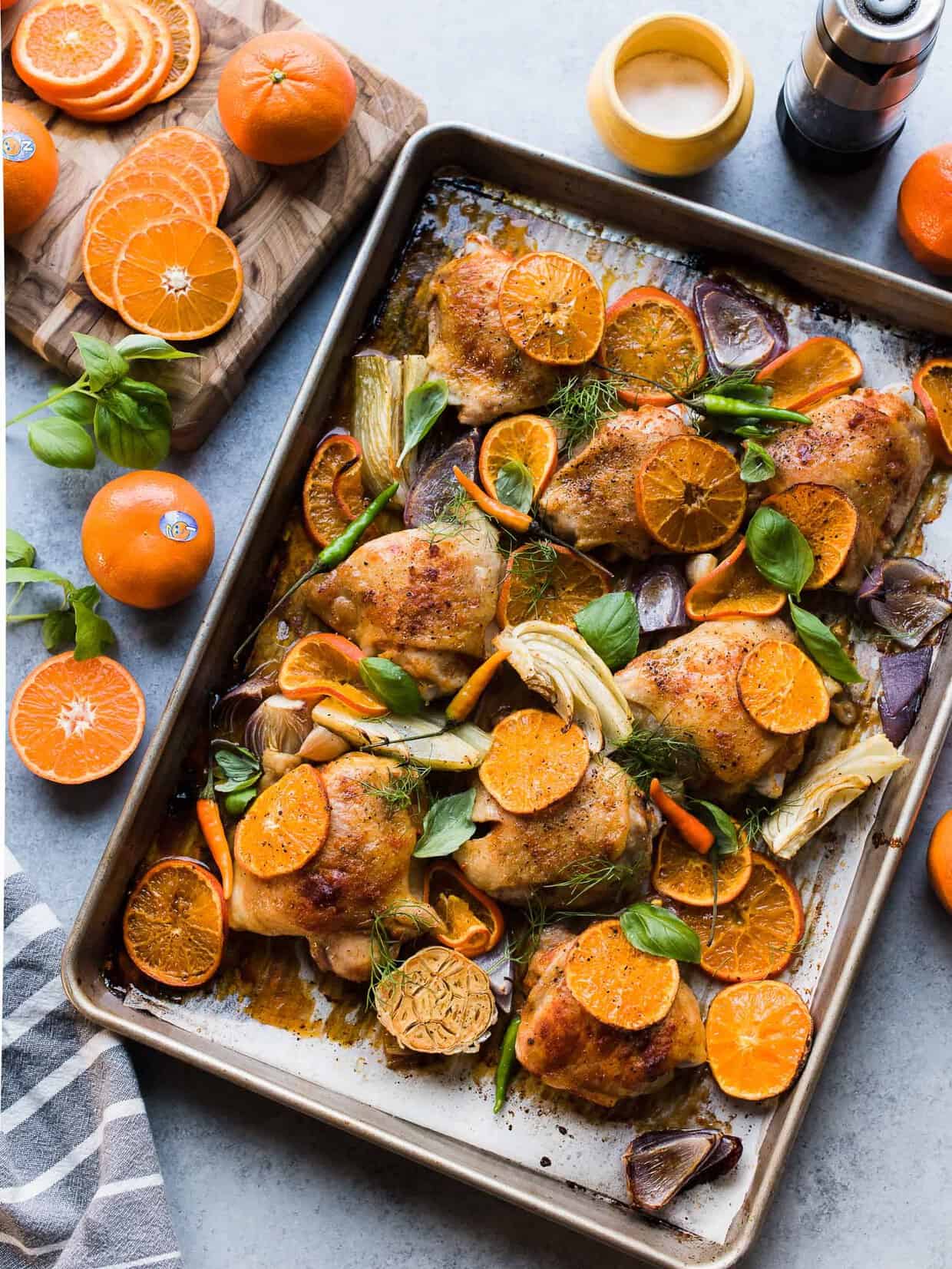 Baking sheet with Thai-Spiced Mandarin Orange Roasted Chicken Thighs made with slices of mandarin oranges.