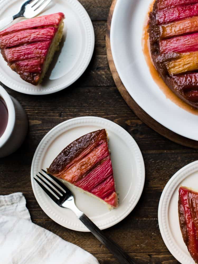 Slices of rhubarb upside-down cake on dessert plates, with beautiful rhubarb stripes.