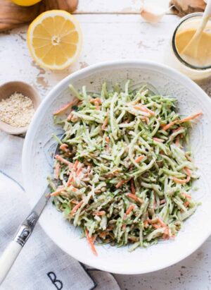 Broccoli Slaw with Garlic Tahini Dressing in white bowl.