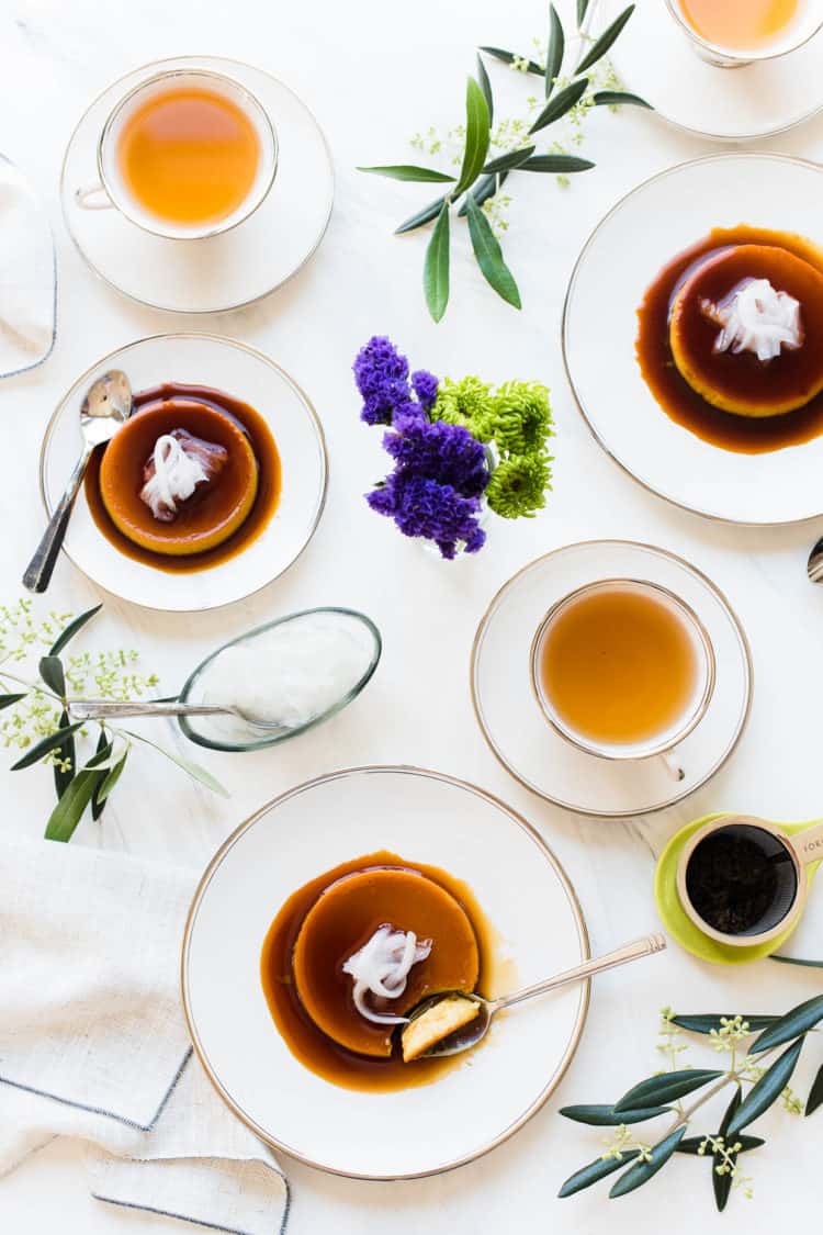 Coconut Leche Flan on white plates on a white table served with tea.