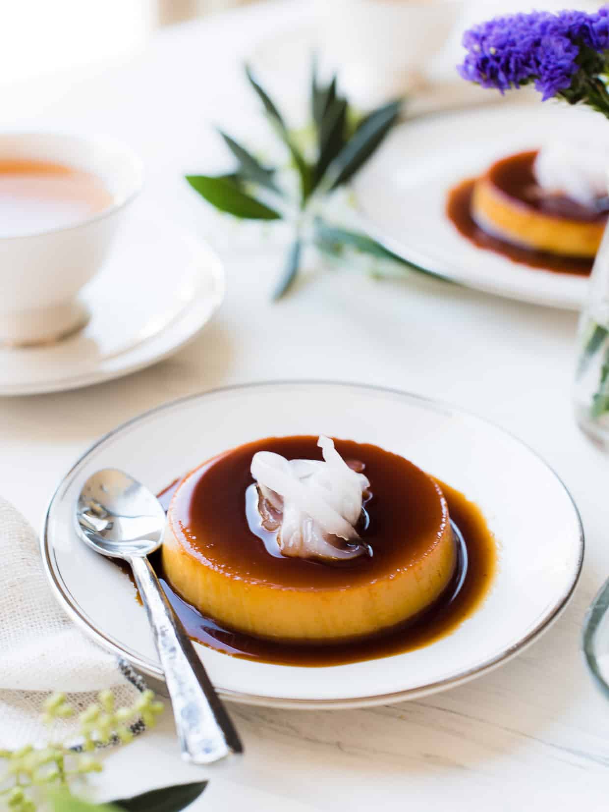 Coconut Leche Flan on a white serving dish topped with young coconut, or macapuno.