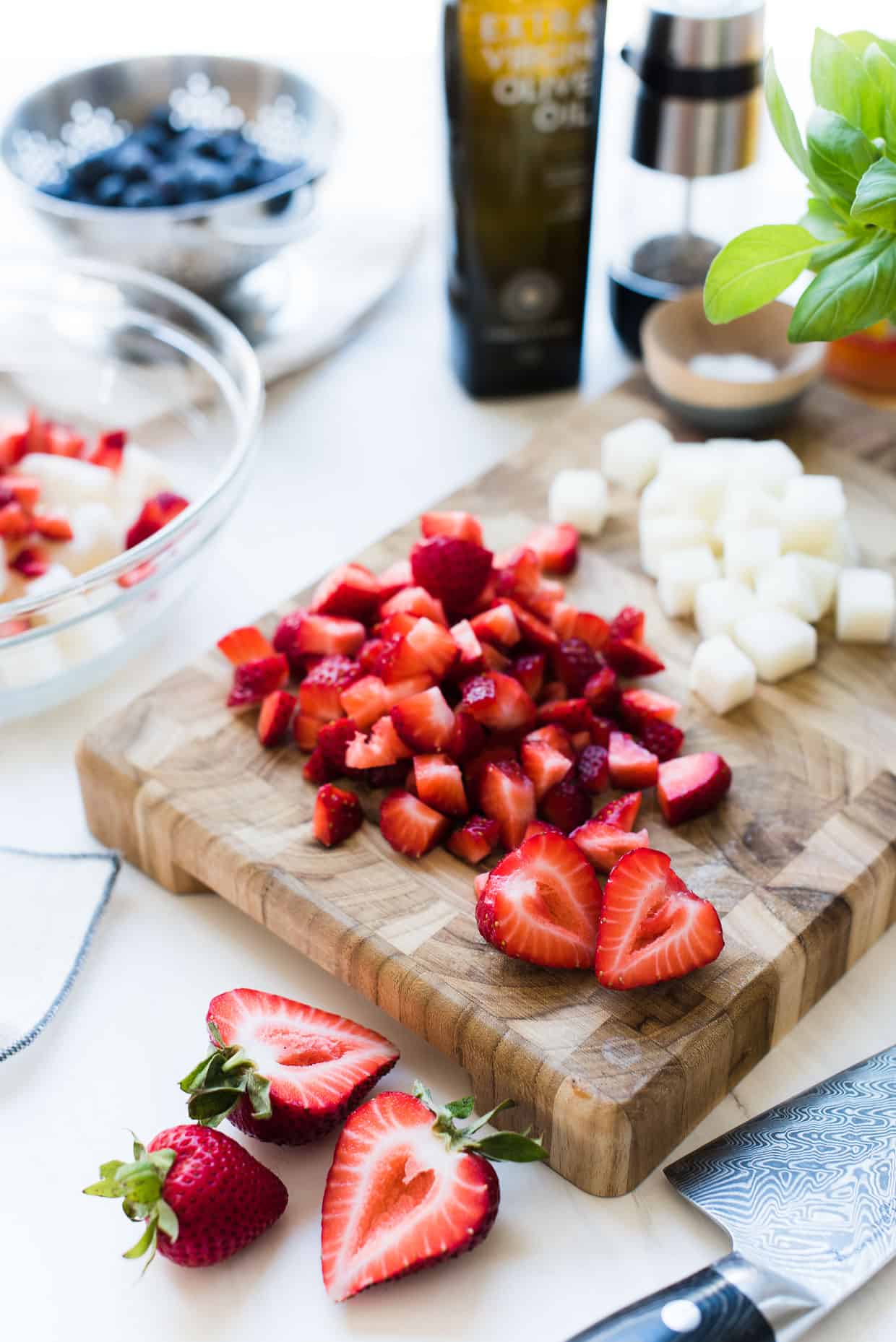 Chopped strawberries and jicama on a cutting board for Red, White and Blue Berry Jicama Salad.