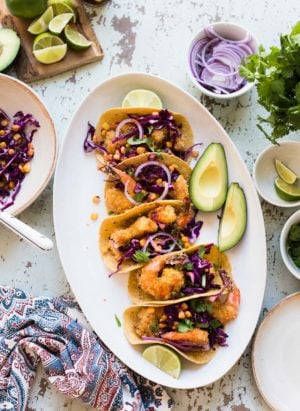 A platter with Oven-Fried Crispy Shrimp Tacos with Pickled Cabbage and Corn.