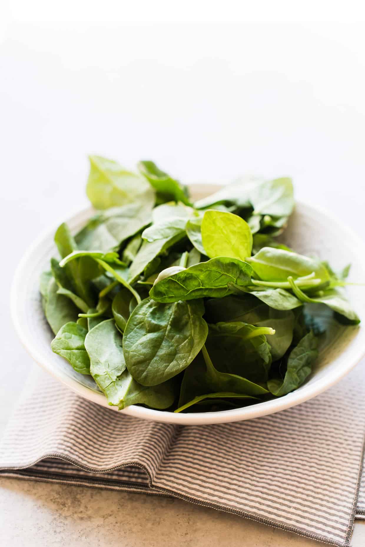 fresh spinach in a white bowl.