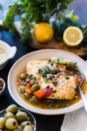 Instant Pot Fish Stew with Tomatoes, Olives and Capers in a cream bowl.