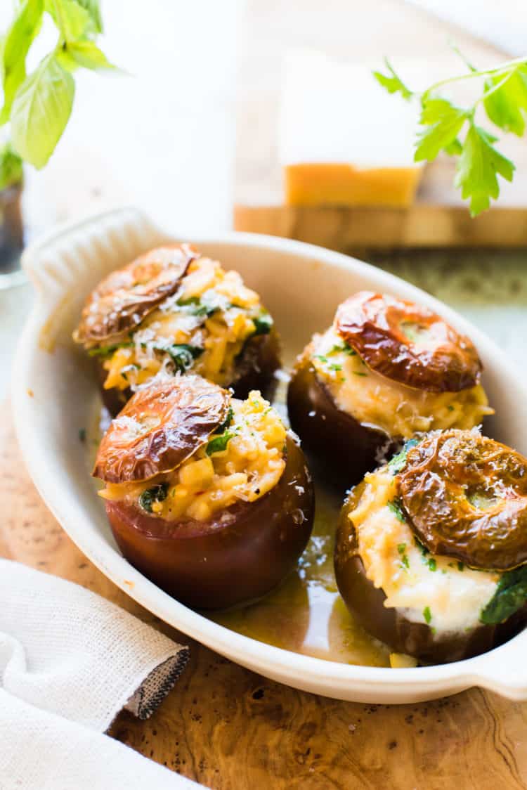 Orzo Stuffed Tomatoes with burrata, parmesan, spinach and yellow squash in a baking dish.