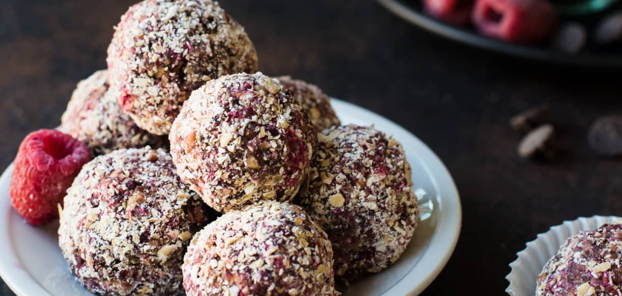 Raspberry Peanut Butter Energy Bites stacked on a dish.