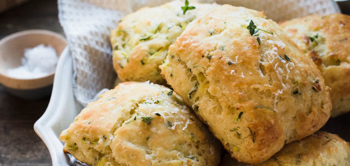Savory Zucchini Scones with Feta and Thyme in a serving platter on a wood table.