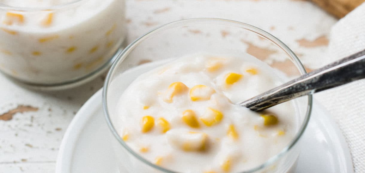 Glass of Ginataang Mais, a creamy sticky rice and corn pudding in coconut milk