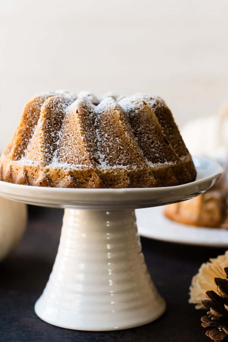 Close up shot of Pumpkin Spice Bundt Cake on a white cake stand.