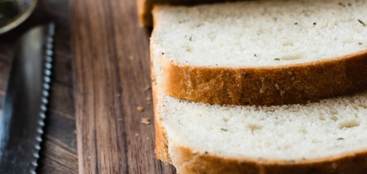 Sliced homemade bread on a cutting board.