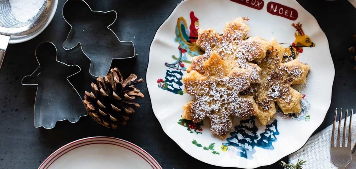 Holiday plates with gingerbread french toast dusted in powdered sugar.