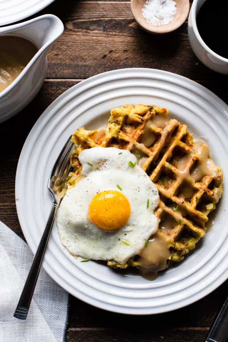 Mashed potato and stuffing waffles served with an egg and gravy.