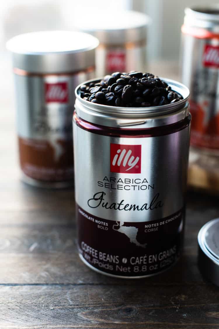 Open canister of illy Arabica Selection Guatemala Coffee on a wooden table.