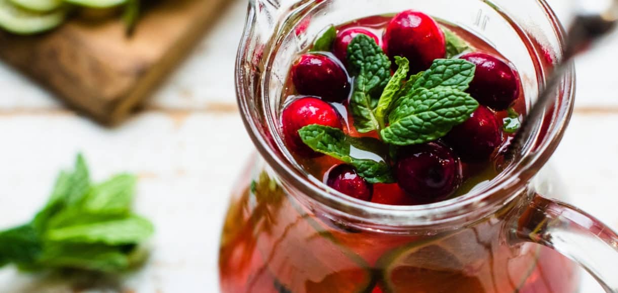 A cranberry pomegranate mojito in a pitcher.