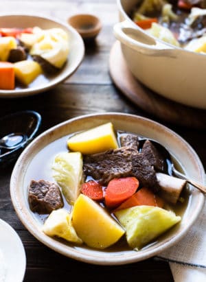 A bowl of Beef Nilaga (Filipino Beef and Vegetable Soup) made in the Instant Pot. Chunks of beef, short ribs, potato, cabbage, carrots, and sweet potato in a bowl.