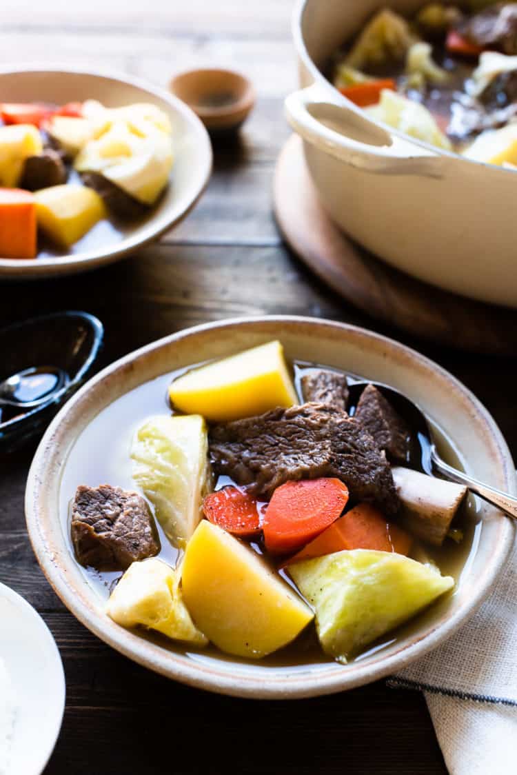 A bowl of Beef Nilaga (Filipino Beef and Vegetable Soup) made in the Instant Pot. Chunks of beef, short ribs, potato, cabbage, carrots, and sweet potato in a bowl.