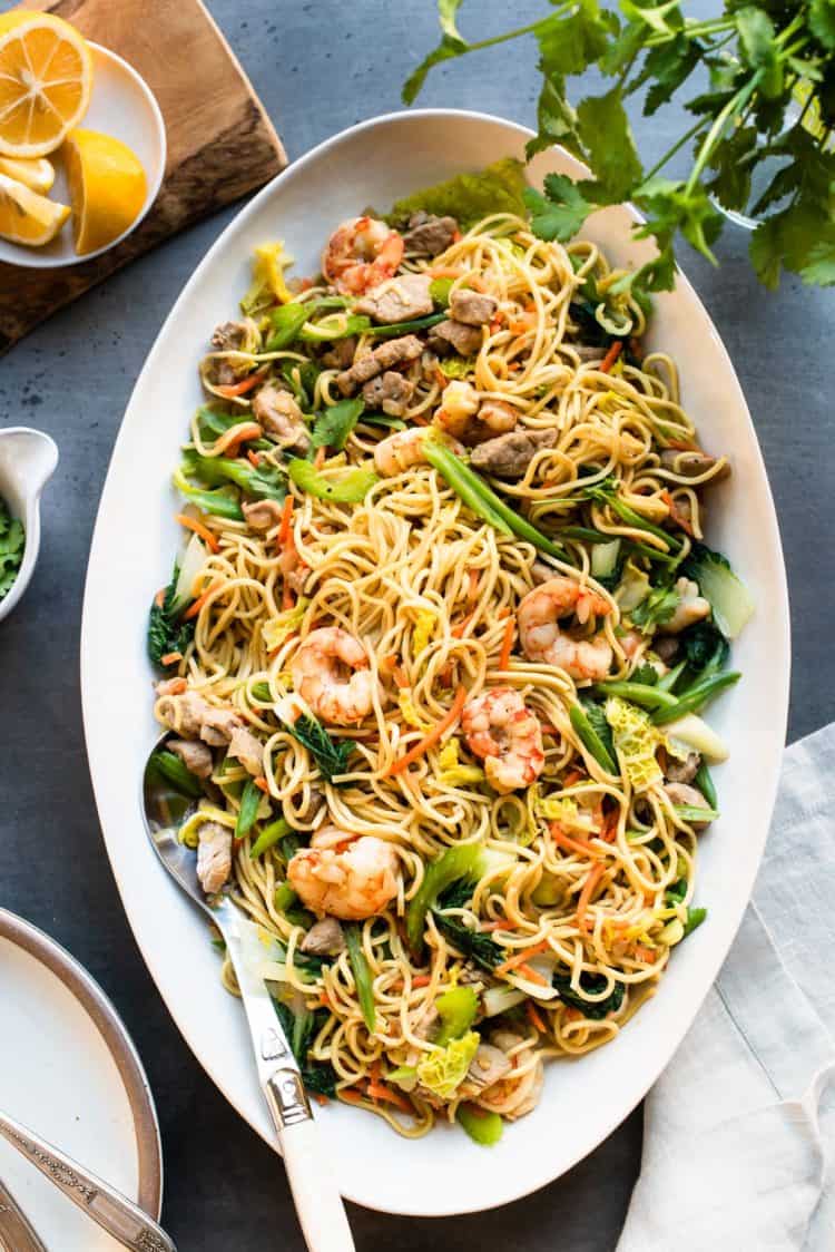 Pancit Canton: Filipino Stir-Fry Noodles with shrimp and vegetables in a white serving platter.