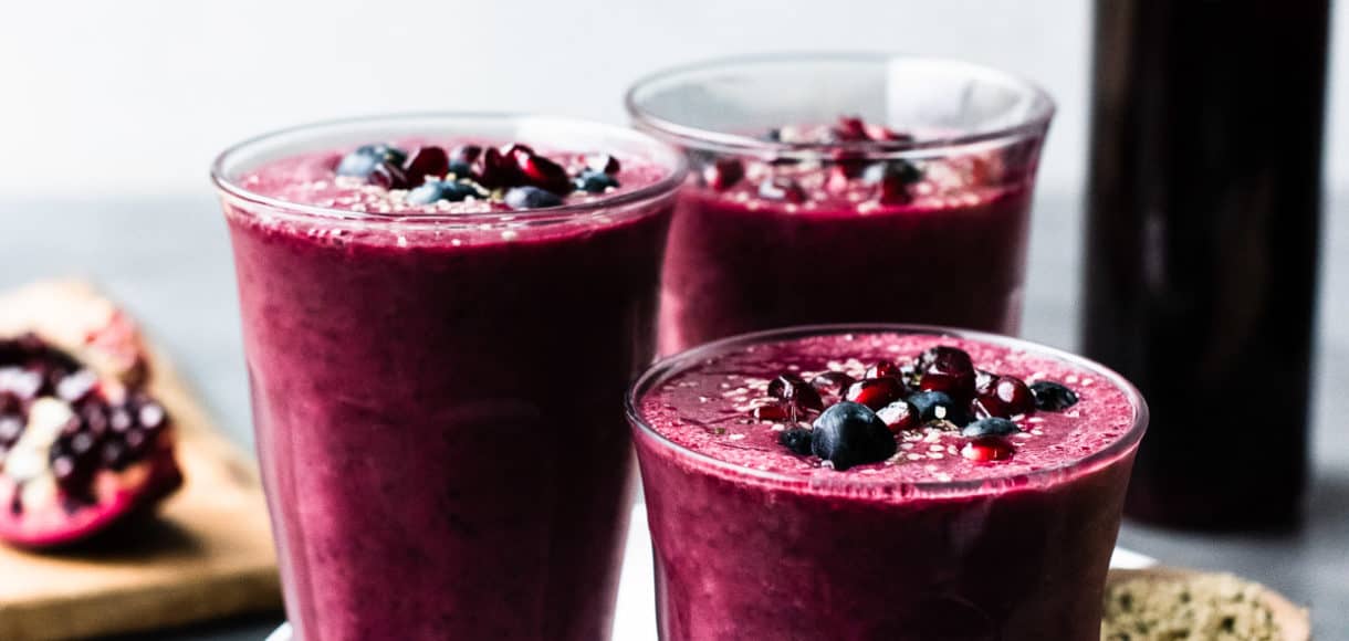 Pomegranate Berry Smoothies topped with blueberries and pomegranate arils.