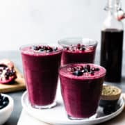 Pomegranate Berry Smoothies topped with blueberries and pomegranate arils.