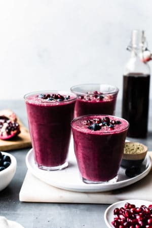 Pomegranate Berry Smoothies topped with blueberries and pomegranate arils.