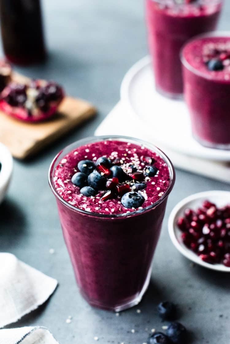 Pomegranate Berry Smoothie topped with blueberries, pomegranate arils and hemp seeds.