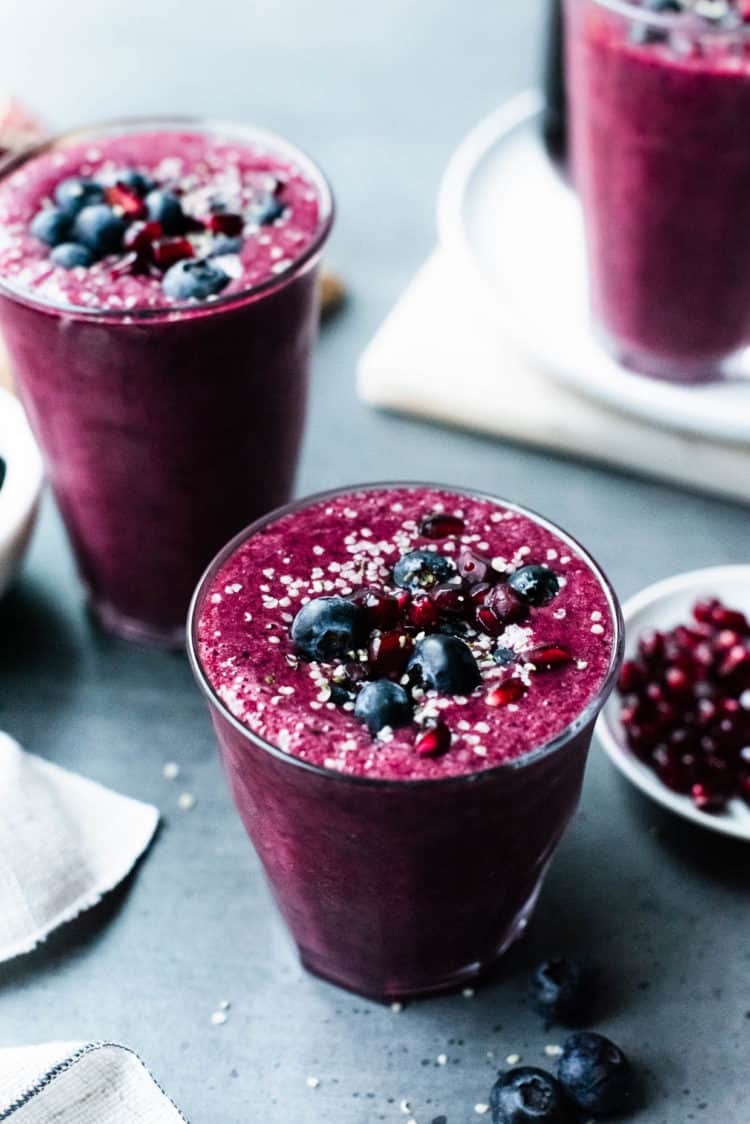 Pomegranate Berry Smoothie topped with blueberries, pomegranate arils and hemp seeds.