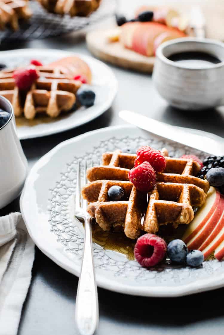 Apple Oatmeal Blender Waffles with syrup and fresh fruit.