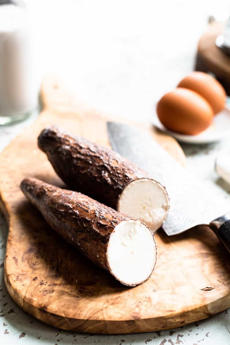 Fresh yuca, cut in half on a cutting board.