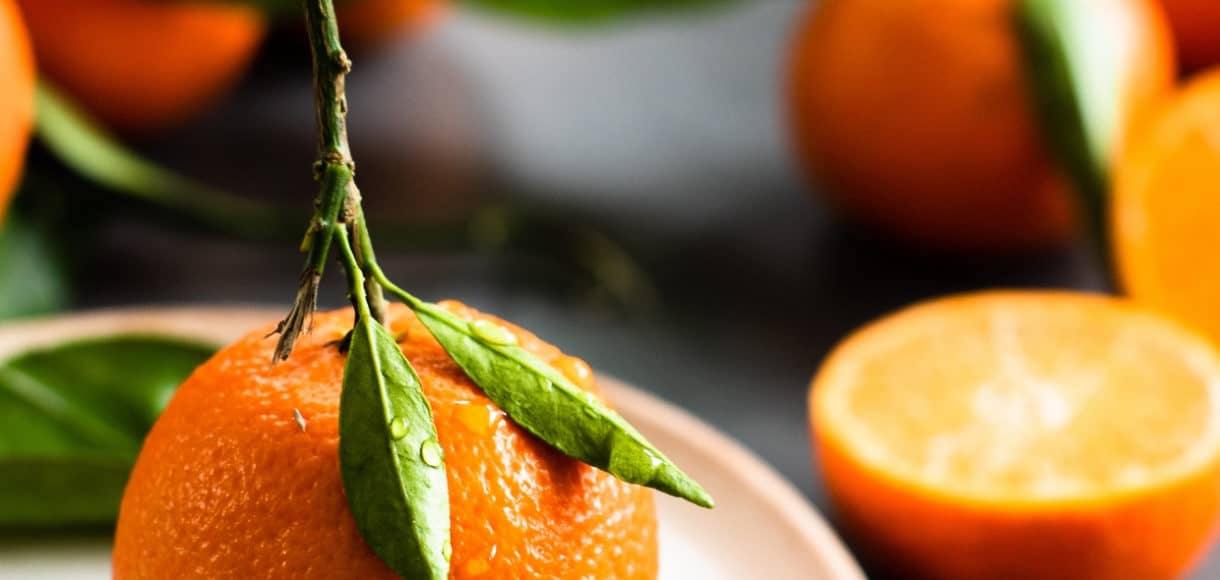 mandarin orange on a plate with oranges in the background