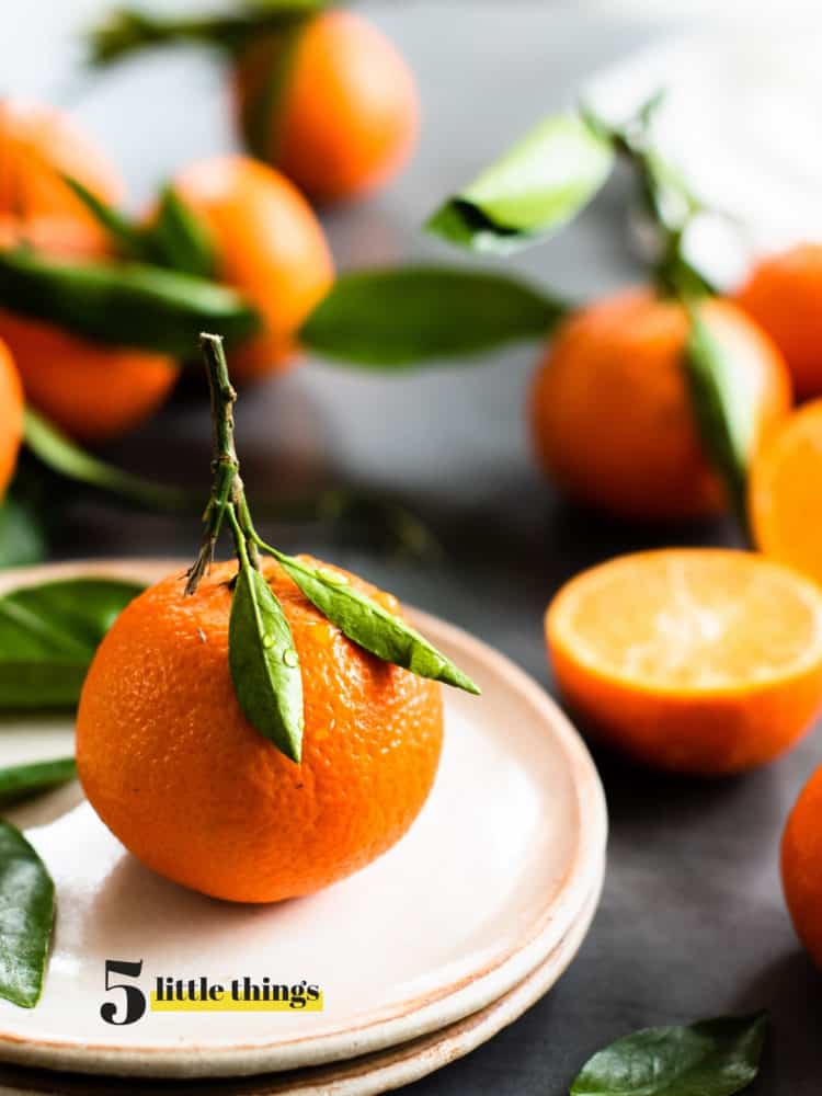 mandarin orange on a plate with oranges in the background