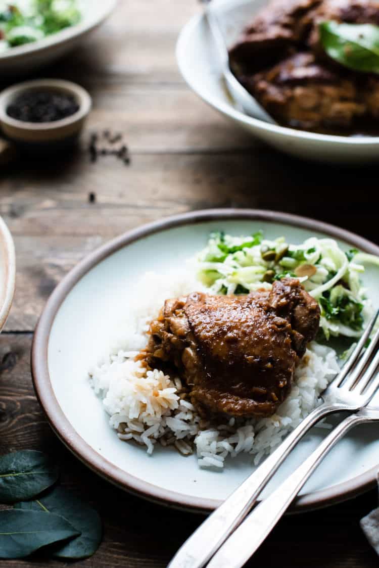 Instant Pot Chicken Adobo on a bed of rice on a plate.