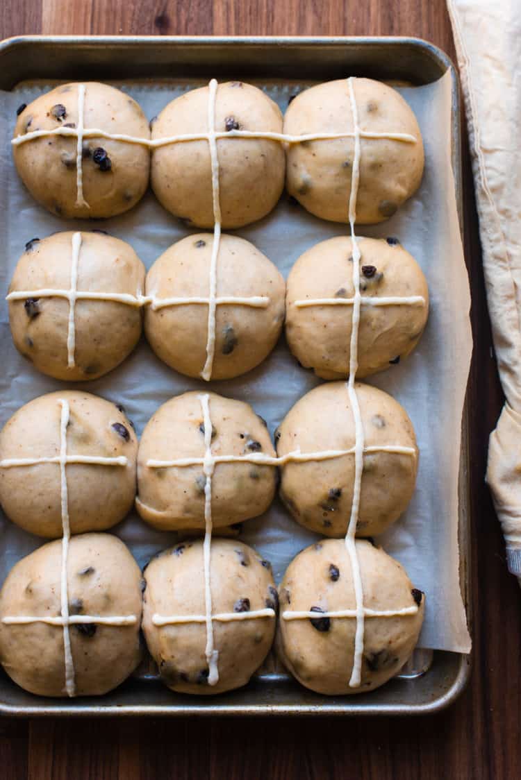 Hot cross buns with piped crosses ready for the oven.