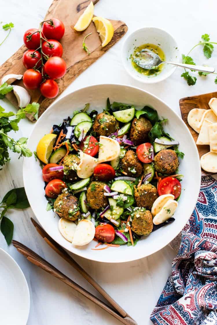 Falafel Salad made with canned chickpeas and served with Lemon Garlic Dressing in a serving bowl with dressing on the side.