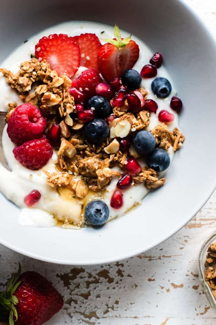 Almond Butter Granola with yogurt, strawberries, raspberries, blueberries, and pomegranate seeds.