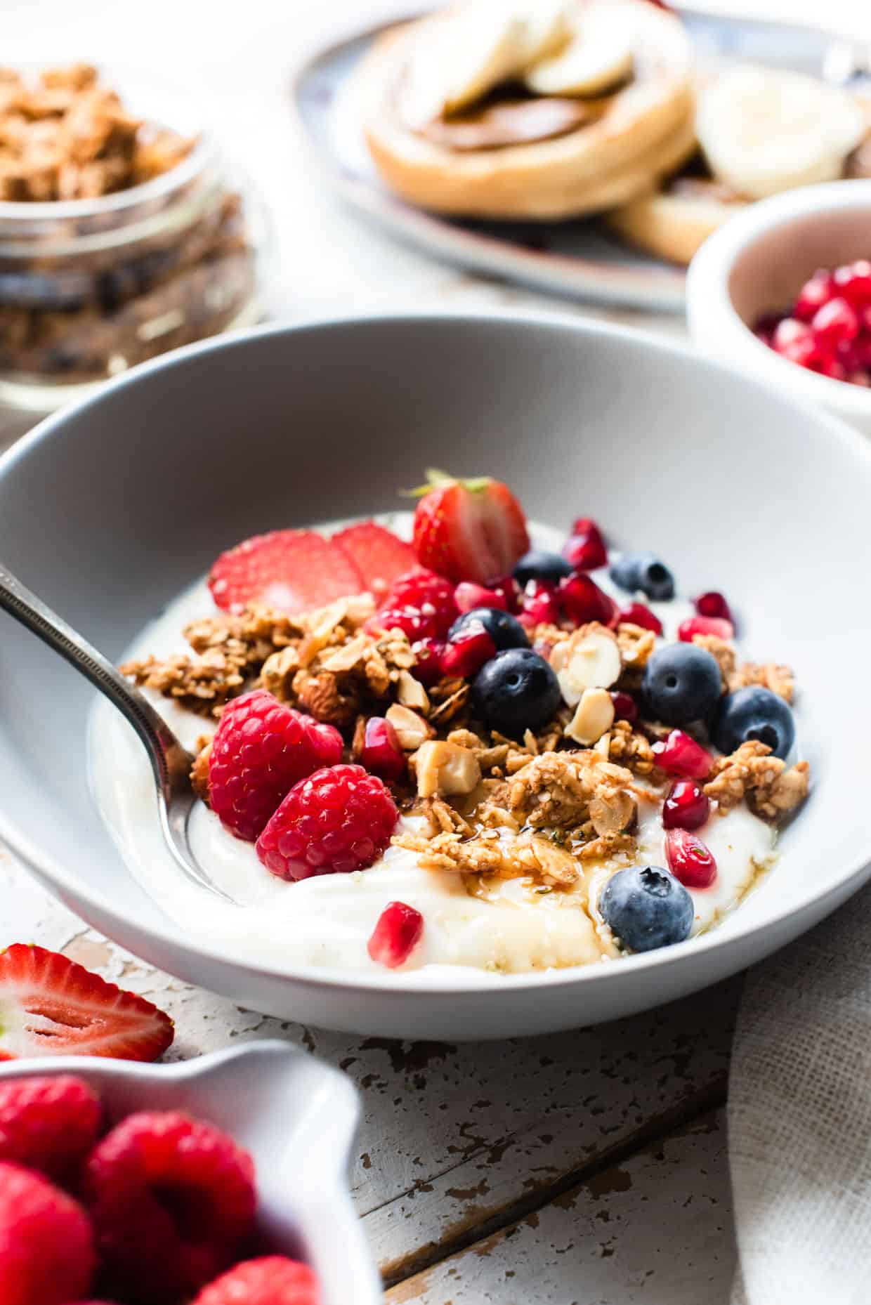 Homemade Almond Butter Granola with yogurt and berries in a bowl.