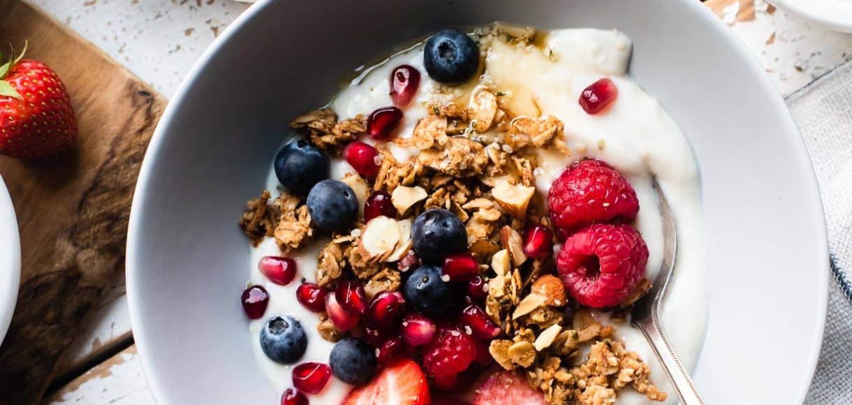 Homemade Almond Butter Granola with yogurt and berries in a bowl.