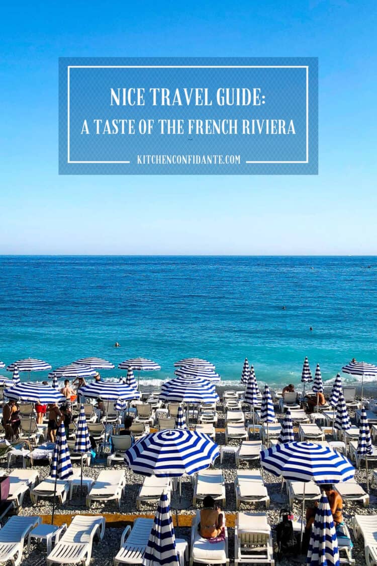 Seaside beach with blue and white striped umbrellas in Nice, France, part of Nice Travel Guide.