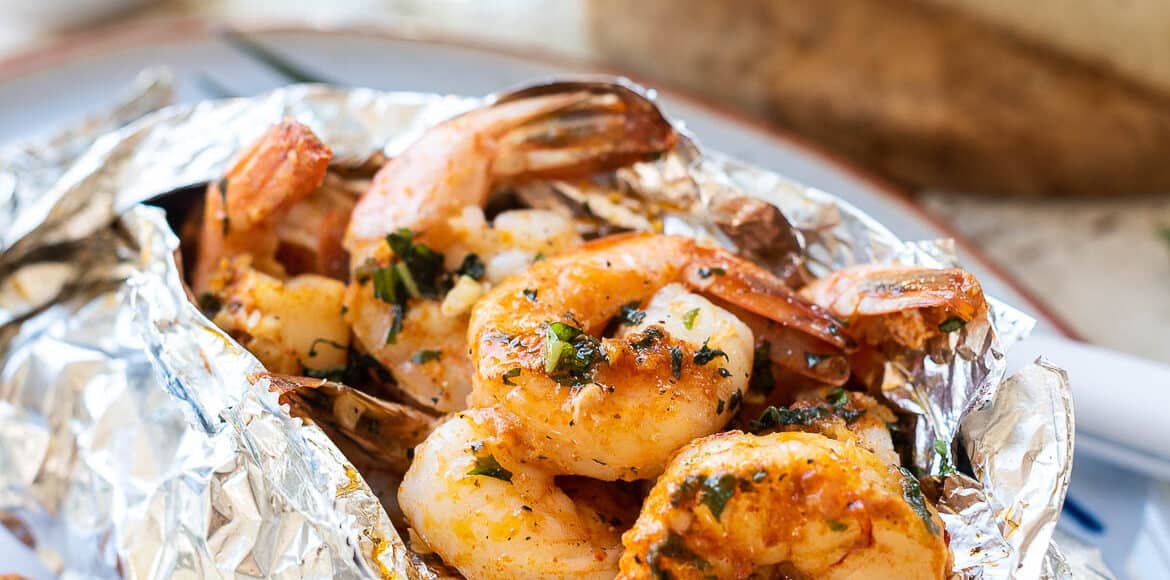 Grilled Shrimp Packets cook shrimp in a foil packet with herbed compound butter and bread on the side.