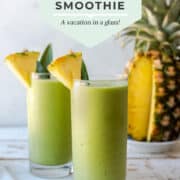 Two glasses of pina colada green smoothie garnished with pineapple.