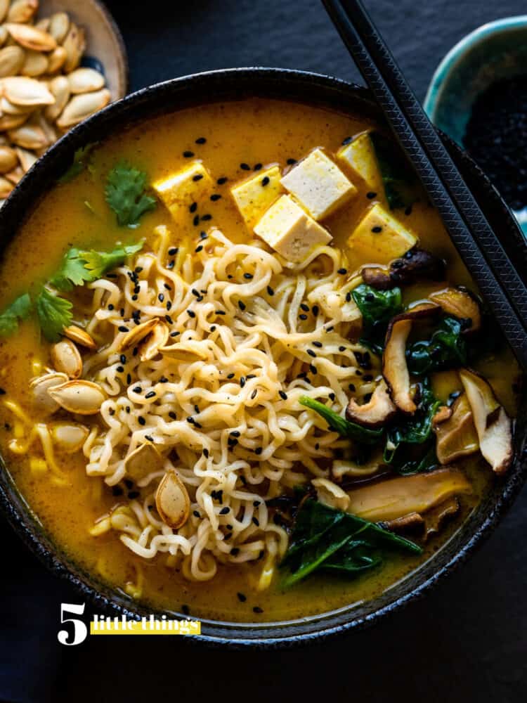 Pumpkin ramen in a black bowl.