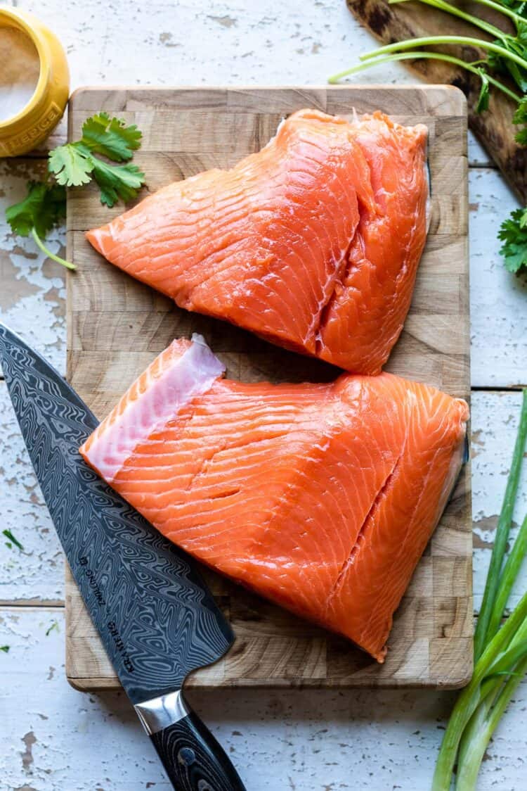 Alaska king salmon on a cutting board with a knife.